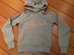 Peak performance hoodie  - Fin ljusblå hoodie från Peak performance. Storlek XS, ganska liten i storleken. Lite sprucken i ”PEAK”. Välanvänd, men har mer kvar att ge. Kan skickas mot porto. 