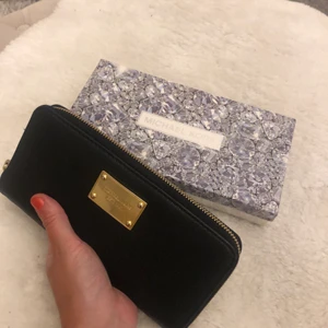 Michael Kors plånbok  - Michael Kors plånbok i toppskick. Endast använd någon enstaka gång och ingenting att anmärka på. Kommer med originalbox. Säljes för 500kr + frakt 62kr