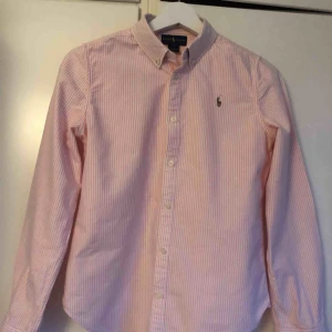 Skjorta - Rosa-vit randig skjorta. Strl 16 år men skulle säga att den motsvarar XS. Mycket fint skick.