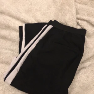 Kostymbyxor - Kostymbyxor från zara med en vit rand på sidan, byxorna har fakefickor & har en resor i midjan för mer stretch. Storlek M men sitter som en S. Det har släppt någon tråd i sömnen vid rumpan, men inget som märks 