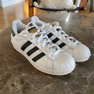  - Klassiska adidas superstar i fint skick! Inte alls använda mycket men lossnat lite i sömmen där fram som kan ses på bild 1. Superfina och perfekta till sommaren! Frakt 63kr