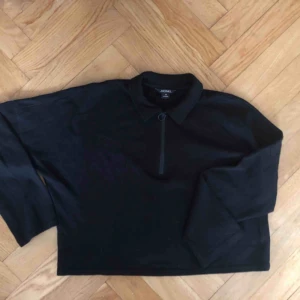  - Svart pikéliknande tröja från Monki med krage och dragkedja. Lite kortare modell. Stl xs. 