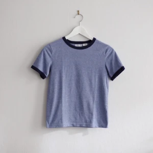  - Blå ”Ringer” t-shirt från Cooperative by Urban Outfitters, lite kortare modell. 60% polyester, 28% bomull, 12% viskos. 