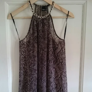  - Genomskinlig linne med fin silverkedja vid halsen. Linnet är aldrig använt. 
