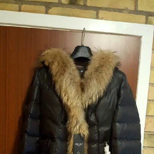  - Hollies dunjacka modell Louise stl 42.
svart. Oanvänd  helt ny. 
bara provad i butiken. 
nyp 5000.
nu 2000.
hollies dunjackor är små i stl. 
Vid intresse Maila mig på thomitza67@hotmail.se 
Thomas. 