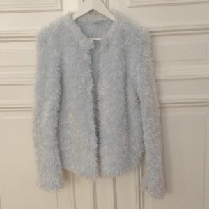  - JätteMysig ljusblå stickad kofta i turkos. One size och 100 % polyester. Helt oanvänd. Märke x-mail. 