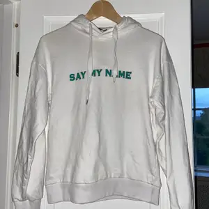 En vit lite tunnare hoodie från NAKD  med grön text där de står ”Say my name”. Den är i storlek S och skulle säga att den är normal i storleken. Så himla skön! Skriv för fler bilder<33