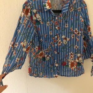 BLÅ BLOMMIG BLUS - Blå blommig blus/skjorta. Aldrig använd. 