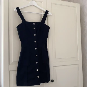 Klänning med knappar - En svart jeansklänning med knappar framtill. Köpte den för ca 200 kr men den är för kort för mig (är ca 172 cm). Därav endast använd en gång. Köparen står för frakt eller eventuellt mötas upp i Göteborg 