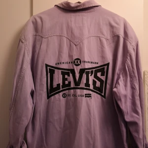 Levis jacka  - Jättefin levis vintage jacka/skjorta i storlek L då den siter mer oversize på mig. Är i jättefin pastell lila färg och jätte snyggt tryck på ryggen som gör hela jackan unik. Är också ett litet levis märke fram på jackan. Om man vill ha flera bilder på detaljer är det bara att skicka till mig så fixar jag. 😊💕 (köparen står för frakten) 