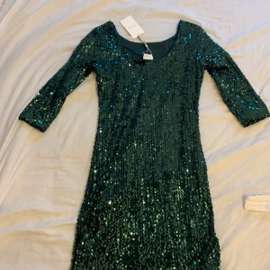 Grön paljettklänning oanvänd  - Oanvänd paljettklänning i storlek 36 figursydd