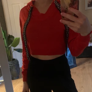 Stickad crop top - Röd crop top med huva / luva. Svarta snören. Endast testad. 