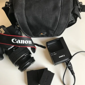 Canon 1200D - Objektiv: Canon, 18-55mm  3 batterier med tillhörande laddare Kameraväska som rymmer kameran.  En systemkamera för nybörjaren som vill börja experimentera med inställningar. Har sparats som ett minne i vårt filmkollektiv då vi började filma med denna, men nu är det dags för den att få brukas igen! Produktspecifikation finns på Canons hemsida.