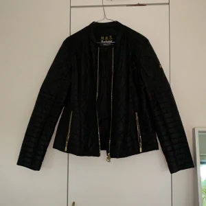 Svart Barbour Jacka i strl 40 - Säljer min fina Barbour jacka som jag köpt hos en återförsäljare i sörmland, den är äkta men kommer inte till användning. Den e rätt tunn så passar bra med en fin stikad under eller som en fin höst jacka. På sista bilden är det en innerficka på vänster sida!Pris kan diskuteras!
