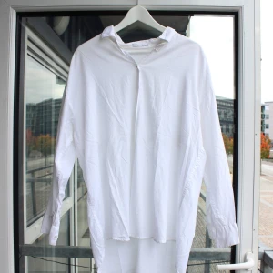 Vit skjorta från Weekday med cool ryggöppning - Superfin skjorta från Weekday, bara använd en gång. Cool öppning i ryggen. Storlek S men oversize så passar även mig som är M.