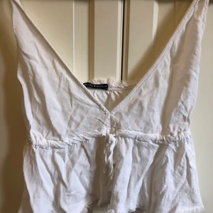 Linne i fin kvalitet  - Vitt linne med djup V-ringning. Storleken kan justeras både i axlar och i midjan. Säljer pga att den inte tyvärr längre kommer till användning.