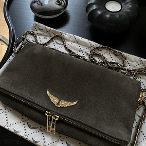 Zadig & Voltaire väska - Säljer min Zadig väska i en mycket snygg grå/brun färg (mocka) med guldiga ditaljer. Mycket fint skick. Vid frågor, skriv privat. Säljer för 1300kr💕💕