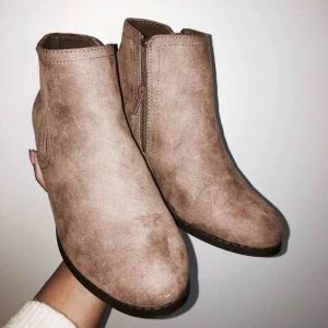  - Brun/beige mocka liknande skor med låg klack samt dragkedja på insidan. Skorna är använda 2 gånger och är inköpta från Primark. Frakt 20kr