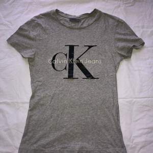 Grå T-shirt i storlek XS från Calvin Klein. Använd men är i bra skick. Frakt ingår i priset!