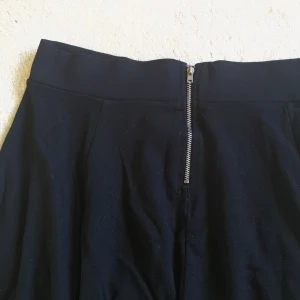  - Svart kjol med dragkedja i bak. 