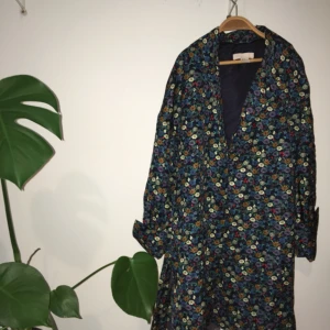  - Så snygg kappa/ blus! Blå bas i skimrande tyg med blommor, st S men passar XS-M. Helt oanvänd och säljes endast pga pengabrist, pga så himla fin!! Funkar som kappa eller som blus för inhomhusbruk på höst/ vinter. 