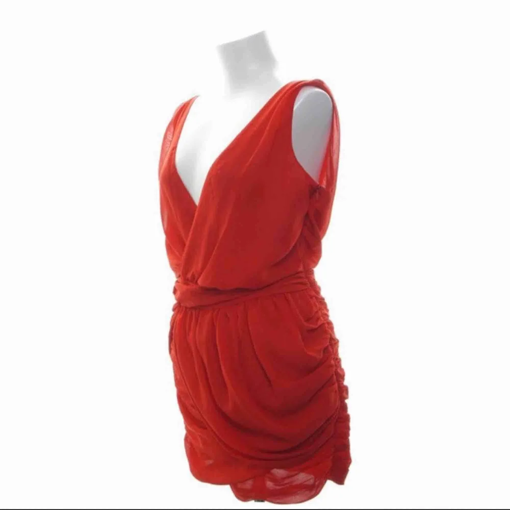 Röd cocktailklänning från Dry Lake. Köpt för 1000kr, bara använd 1 gång så superbra skick! Snygg urringning fram & bak, veckat tyg över mage och rumpa. Frakt tillkommer. Klänningar.
