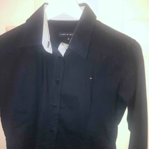  - Tommy hilfiger skjorta i marinblå färg. Nästan aldrig använd så den är i otroligt bra skick.  Kan mötas upp i Stockholm, köpare står för frakt och tar endast swish. Hör av dig för mer info.