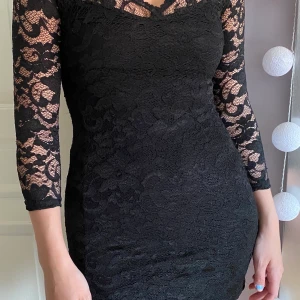 Svart fodralklänning i spets - Klänning med v-ringning och kortare ärmar från märket Zack. I strl XS men passar även S!