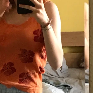 oranget linne - orange, ribbat, linne med röda hibiskus blommor på. fina detaljer vid knapparna🌺🧡 50kr INKLUSIVE FRAKT!!! 🚚 