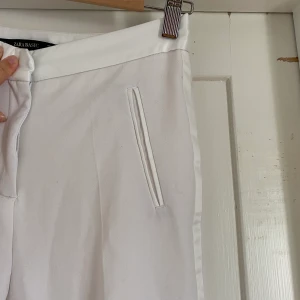 Vita kostymbyxor Zara - Vita kostymbyxor från Zara, använda fåtal gånger. Sidenrand. Slutar vid ankeln cirka. 