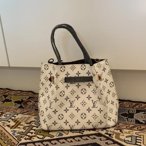 Snygg väska  - Väskan är i bra skick men säljer pga av att den inte kommer till användning. Den kommer med en tillhörande necessär. Frakten tillkommer. Skriv vid om ni har frågor eller är intresserade🤍✨