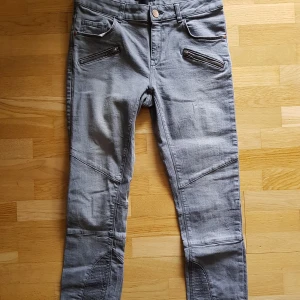 Bikerjeans stl.38. Fint skick! - Snygga bikerjeans i grått med stretch. Ganska låga i midjan som är 40,5 cm rakt över.