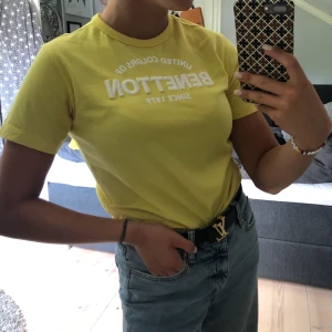 T-shirt med text - ill-gul T-shirt från benneton med texten ”benneton”, FRAKT INGÅR I PRISET, kontakta för fler bilder eller frågor, buda gärna