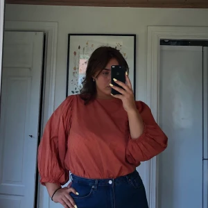 Somrig Blus - Peach/orange blus från Gina Tricot. Fin i passformen med puffarmar och fin knäppning i ryggen, se bild tre. Luftig och perfekt för sensommar kvällar. Max använd två gånger, så i väldigt bra skick. Nypris 250, köpare står för frakt.
