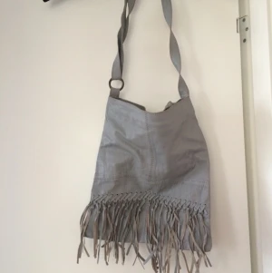  - Skinnväska grå köpt från Vila.
Fransar framtill. 
Frakt tillkommer.