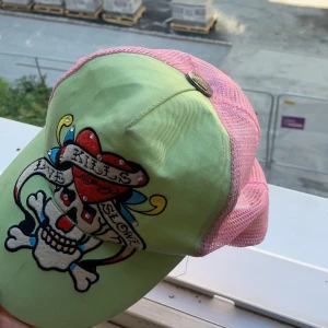 Ed hardy keps  - Askans Grön o rosa ed hardy keps bra skick, vet ej storlek men den passar mig så ba du har ett huvud typ