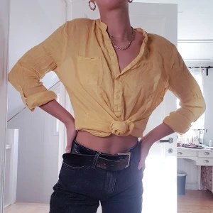 Gul skjortblus - En gul skjortblus som är lite längre men går att knyta upp eller styla på andra sätt💙 Storlek M men sitter på mig som är S som på bilden.