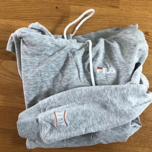 Fila grå hoodie - Grå hoodie från märket Fila. Köptes av tidigare säljare på spock och har även lånat hennes bilder. Trots att tröjan är begagnad är skicket fint och jag hittar varken fläckar eller slitningar. Frakten är inkluderad i priset. Skriv privat vid frågor! :)