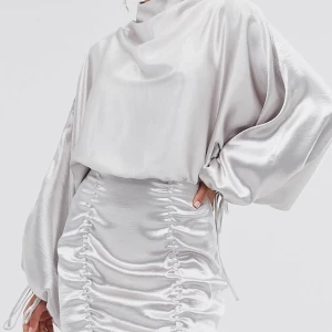 PERFEKTA festklänningen!!! - Säljer nu min älskade klänning. Superfin silvrig klänning med lite öppen rygg och snygga rysch-detaljer. Perfekta nyårsklänningen! Strl 38. Slutsåld på Asos, nypris ca 600, säljer för 250kr 🥰