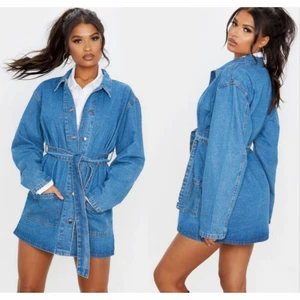 Blå lång jeansjacka m knytband XS - Färg: blå.  Strl: 32 (Men är "over-size"!!) Passar 32-36.  Skitsnygg helt ny längre jeans jacka med knytband i midjan. Stora fickor framtill. Sluts igen med knappar framtill. OBS!!! Aldrig använd - Helt NY! Med lappar kvar. Betalning via swish.