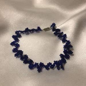 Supercoolt halsband i chokermodell med zigzag och blommönster i fina blåa beads! One-of-a-kind och piffar upp alla outfits🥰