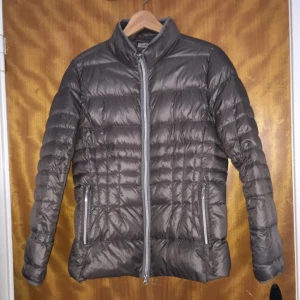  - Nypris 699. Tunn dunjacka i snygg färg passar bra till vår/höst. Storlek 40/M