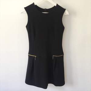 Enkel och snygg svart klänning med guldiga detaljer
