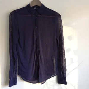  - Skjorta från American Apparel. Lila/blå i färgen. Transparent. Normalt skick. 

Köpare står för frakt. 