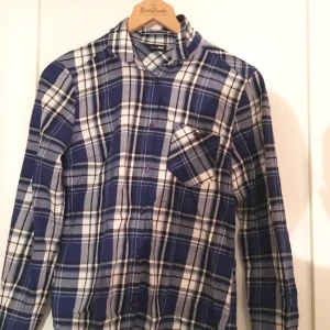  - Blå/vit/svart rutig skjorta från JC. Aldrig använd!