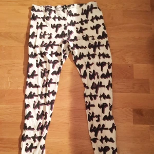  - Vita tights med text med lila bakgrund, från H&M.