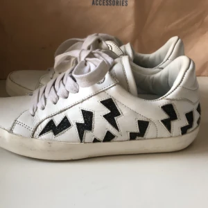 Zadig & Voltaire skor - Ursnygga Zadig sneakers med blixtar på som  blir lätt guldiga i solljus. Köpta på hemsidan för ett halvår sedan, knappt använda. Skorna är rena, det är endast modellen som ger en ”sliten” look. Strlk 36, köpta för 295€, ca 3000kr. Tror inte de går att köpa i butik längre. Kommer med dustbag.                                          