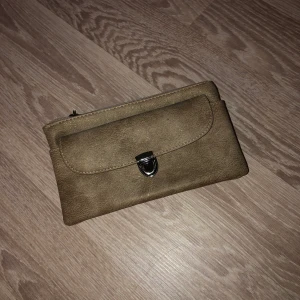 Beige clutch - Beige clutch med lite guldglitter i, rymliga fack. Fint skick! 