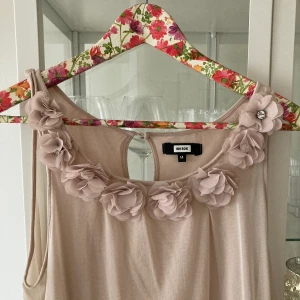 Söt blekrosa topp med blommor i stolek M - Jätte fin och söt topp i storlek M. Strassdetaljer samt innertyg så ej genomskinlig.
