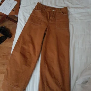 Bruna monki byxor - Ett par skitsnygga bruna byxor från monki. Som är vida med en cool synlig sömn längs benet, längst ner på byxan och runt fickorna. Säljer för att de inte passar min stil längre. Frakt tillkommer.